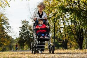 nonna e sua autistico mille dollari figlia godendo vacanza insieme all'aperto, dire bugie su verde erba su coperta e sorridente per telecamera. tempo libero famiglia stile di vita, felicità e momenti. foto