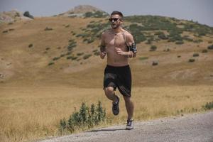 sportivo uomo corridore in esecuzione su montagna altopiano nel estate foto