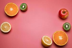 frutta su il rosa sfondo. arancia, Limone, kiwi, Mela. gratuito spazio per testo. foto