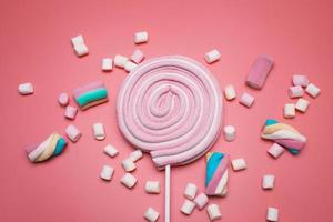 marshmallows e lecca-lecca pop su il rosa sfondo. foto