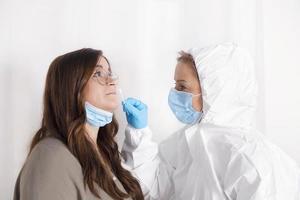 covid 19 test. laboratorio lavoratore indossare personale protettivo attrezzatura analisi giovane donna per coronavirus utilizzando nasale tampone metodo. foto