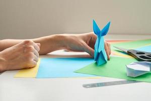 Fai da te concetto. donna rendere origami Pasqua coniglio a partire dal colore carta. origami Lezioni foto