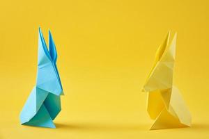 Due carta colorato origami esater conigli su un' giallo sfondo foto