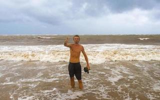 uomo è su su spiaggia durante uragano e gode Messico. foto