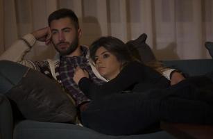 giovane coppia Guardando tv nel sera a casa foto