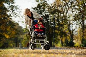 nonna e sua autistico mille dollari figlia godendo vacanza insieme all'aperto, dire bugie su verde erba su coperta e sorridente per telecamera. tempo libero famiglia stile di vita, felicità e momenti. foto