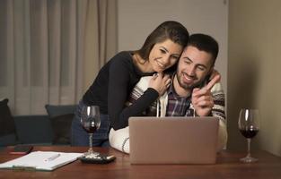 giovane coppia gestione finanze, rivedere loro banca conti utilizzando il computer portatile computer. donna e uomo fare lavoro d'ufficio insieme, pagare le tasse in linea su taccuino pc foto