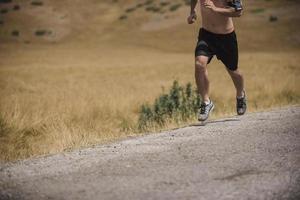 sportivo uomo corridore in esecuzione su montagna altopiano nel estate foto