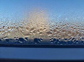finestra coperto con congelato gocce di condensa acqua foto
