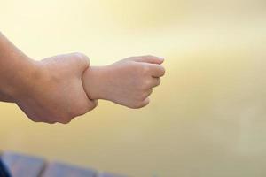 La madre di mano Tenere del bambino braccio per paura di caduta in il acqua foto