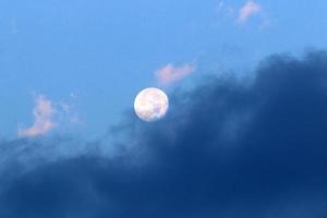 Luna e nuvole nel il cielo al di sopra di il mare foto