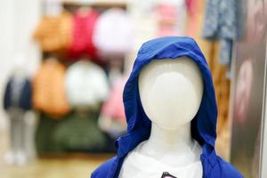 avvicinamento chiaro viso di ragazzo manichini indossare il infanzia Abiti design con sfocato sfondo di il negozio foto