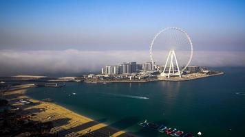 dubai, Emirati Arabi Uniti su 27.05.2021. marina jbr spiaggia sabbie e onde meraas blu acque isola e ain gigante Ferris ruota durante tramonto. il migliore turista destinazione nel unito arabo emirati. foto