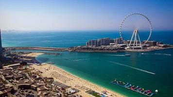 dubai, Emirati Arabi Uniti su 27.05.2021. marina jbr spiaggia sabbie e onde meraas blu acque isola e ain gigante Ferris ruota durante tramonto. il migliore turista destinazione nel unito arabo emirati. foto