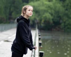 ritratto di giovane ragazza sorridente. bellissimo donna in piedi uno persona all'aperto. un' allegro, lungo brunetta dai capelli, Marrone occhi femmina ha un' positivo emozione la libertà di tempo libero attività nel un' naturale parco. foto