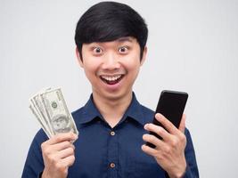 asiatico uomo allegro contento viso holidng mobile Telefono e i soldi dollaro nel mano ritratto foto
