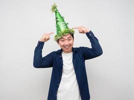 asiatico uomo punto dito a il suo verde cappello celebrazione nuovo anno concetto foto