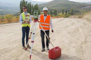 perito ingegnere è misurazione livello su costruzione luogo. geometri garantire preciso misurazioni prima impresa grande costruzione progetti. foto