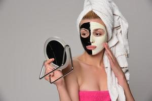 bellissimo femmina modello con nero e bianca facciale cosmetico maschera foto