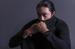 bello asiatico moda guardare uomo in posa nel studio su nero sfondo, stile di vita moderno persone concetto foto