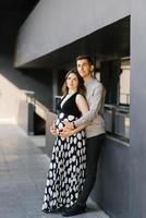 un' giovane coppia in attesa per loro bambino. il marito abbracci il suo della moglie stomaco. primo gravidanza. foto