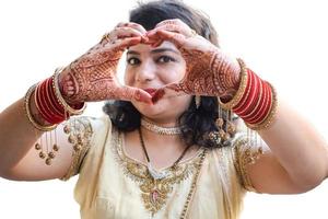 bellissimo donna vestito su come indiano tradizione con alcanna mehndi design su sua tutti e due mani per celebrare grande Festival di karwa chauth con pianura bianca sfondo foto