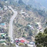 vista aerea dall'alto dei veicoli stradali che guidano su strade di montagna a nainital, india, uttarakhand, vista dal lato superiore della montagna per il movimento di veicoli stradali foto