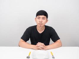 asiatico uomo sedersi a tavolo pensiero di cibo foto