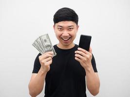 asiatico uomo Tenere i soldi e Telefono sensazione contento bianca sfondo foto