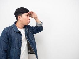 lato Visualizza asiatico uomo jean camicia gesto mano al di sopra di testa eccitato guardare foto