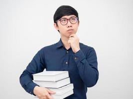 asiatico uomo indossare bicchieri Tenere libro e pensiero qualcosa ritratto bianca sfondo foto