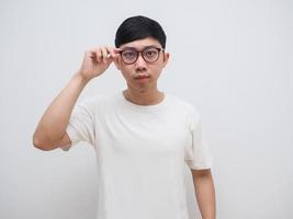 asiatico uomo bianca camicia toccare a il suo bicchieri sentire confuso a viso bianca camicia Guarda a telecamera su bianca isolato foto