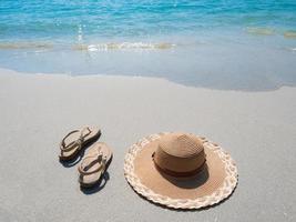 donna scarpa e cappello su il spiaggia con oceano onda viaggiatore concetto foto