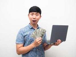 asiatico uomo blu camicia Tenere il computer portatile con un' lotto di i soldi eccitato viso isolato foto