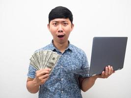 asiatico uomo sentire stupito con ottenere un' lotto di i soldi di Lavorando in linea foto