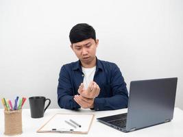 asiatico uomo seduta a ufficio posto di lavoro massaggio dolorante polso ufficio sindrome concetto foto