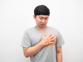 asiatico uomo grigio camicia gesto dolore cuore bianca sfondo foto