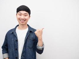 asiatico uomo jeans camicia sorridente gesto puntamento dito a copia spazio foto