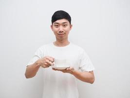asiatico uomo bianca camicia contento Sorridi hold caffè tazza nel mano invitare concetto su bianca isolato sfondo foto