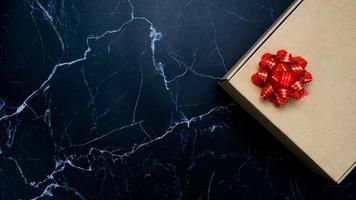 regalo scatola rosso nastro su nero marmo superiore Visualizza copia spazio foto
