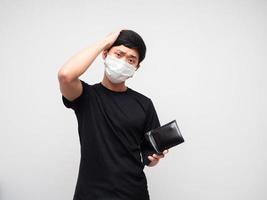 asiatico uomo indossare proteggere maschera Tenere portafoglio e toccare il suo testa sensazione triste nad annoiato su bianca sfondo foto
