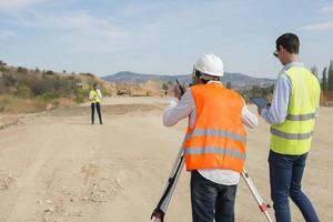 perito ingegnere è misurazione livello su costruzione luogo. geometri garantire preciso misurazioni prima impresa grande costruzione progetti. foto