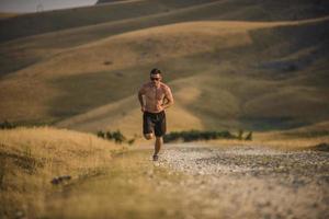 sportivo uomo corridore in esecuzione su montagna altopiano nel estate foto