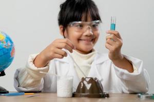 formazione scolastica, scienza, chimica e bambini concetto - bambini o studenti con test tubo fabbricazione sperimentare a scuola laboratorio foto