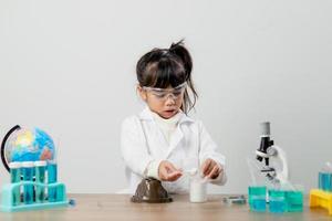 formazione scolastica, scienza, chimica e bambini concetto - bambini o studenti con test tubo fabbricazione sperimentare a scuola laboratorio foto