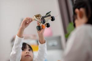 gli studenti asiatici imparano a casa a codificare auto robot e cavi di schede elettroniche in stelo, vapore, matematica ingegneria scienza tecnologia codice informatico in robotica per bambini concetto. foto