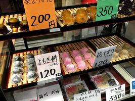 mochi dolci, giapponese dolce mettere su Schermo nel un' mobiletto. colorato, invitante turisti per acquistare per provare nel Pasticcino negozio a il kuromon ichiba mercato, osaka. foto