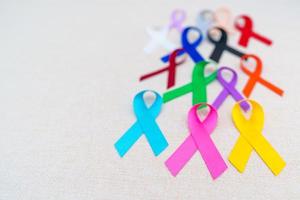 mondo cancro giorno, febbraio 4. colorato nastri per supporto persone vivente e malattia. assistenza sanitaria, battagliero, medico e nazionale cancro sopravvivenza giorno, autismo consapevolezza giorno concetto foto