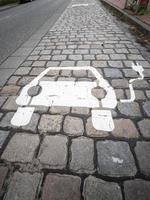 elettrico auto ricarica cartello dipinto su pavimentazione pietre su un' città strada. foto
