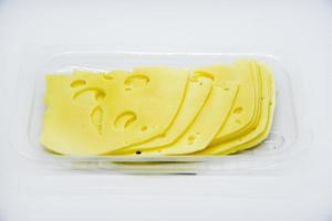 affettato pezzi di giallo formaggio con fori su il piatto. tritato formaggio avvicinamento. delizioso formaggio fette. foto